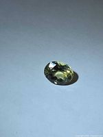 Oval-cut yellow tourmaline side view on white background