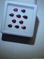 Top view of nine pear-shaped rubies in display box