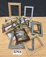 Pile of over twenty assorted 5"×7" plastic frames