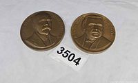 Obverse view of both medallions showing portraits and names