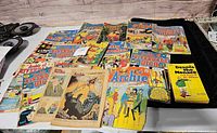 Full lot of vintage comic books spread out on table