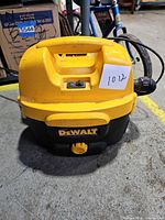 Front view of DeWalt wet/dry vacuum showing housing, handle, switch, hose port, and DeWalt logo
