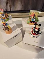 Four Disney Thimble Collection character thimbles on boxes