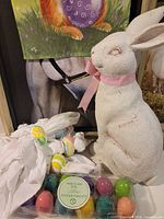 overall shot showing rabbit statue, porcelain eggs, napkin rings and backdrop print