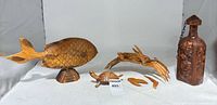 Group shot of all four carved wooden items: fish, crab, turtle, bottle