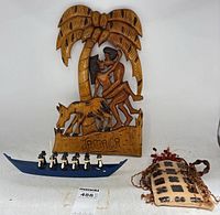 Group view showing all three items: wood plaque, canoe with figures, ceramic holder