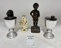 Front view of both candle stands with wax contents plus two figurines