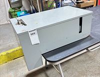 Front and top view of grey metal storage box with hasp latch and MaxSold tag