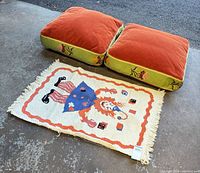 Two floor pillows and woven rug overview