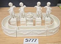 Overall view showing four cherub figures, urn, and planter sections