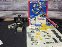 Overview showing Erector set box with parts tray, pamphlets, cameras and Casio TV
