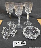Three Waterford wine glasses, shamrock paperweight and cut bowl displayed together