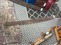 Full view of the 71-inch crosscut saw laid on floor showing entire blade and attached wooden handle