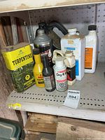 Shelf with seven assorted automotive fluid containers