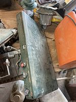 Closed green Coleman stove case with lanterns visible