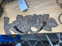 Full view of cast iron grapevine wall hook on tabletop