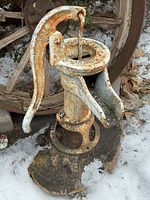 full view of cast iron cistern pump showing handle, spout, base