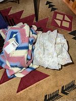 Crocheted blanket and folded sheets on floor