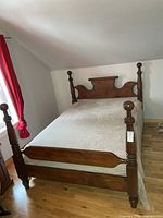 Full view of assembled four-post bed with mattress and bedding