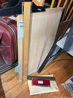 Drafting board, T-square, red instrument case and green metal scale in envelope