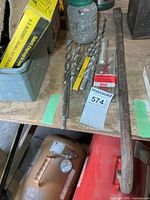 Shelf with multiple masonry drill bits, plastic jar of nails, pry bar