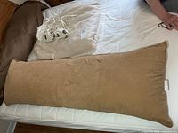 Blanket folded with body pillow on mattress