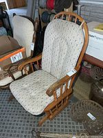 Front angled view of glider rocker showing wood frame and cushions