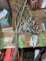 pile of spiral ground anchors, four-prong hooks, plumbing snake visible