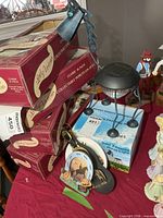 Group shot showing boxed porcelain dolls, boxed solar light, assembled solar light and other decor items