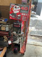 Overall lot showing welder on cart with accessories and box