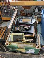 Box with assorted picture frames of various sizes and materials