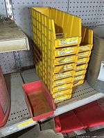 Stack of yellow bins with red bin in foreground