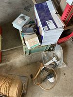 Milk crate with boxed lights, electrical box and timer, plumbing parts on floor