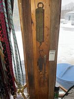 Full view of scales and spearhead hanging on plank