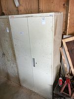 Front view of closed beige metal cabinet with two swing doors