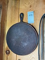 Front view of cast iron crepe pan hanging on wall