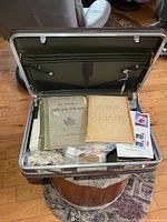 Overview of open briefcase showing albums and bags of stamps