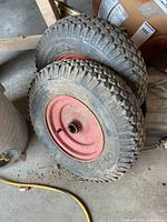 Pair of pneumatic wheels and tires on floor