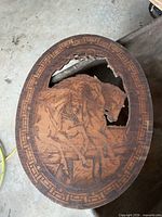 Full view of oval wood plaque showing horse engraving and broken edge
