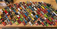 Entire spread of approximately 140 mixed diecast cars on tabletop