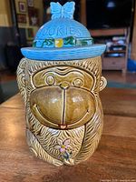 front view of ceramic monkey cookie jar showing face, hat with COOKIES text