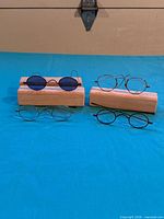 Four pairs of eyeglasses displayed on wooden blocks, overall view