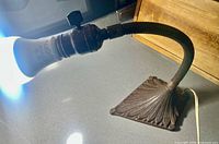 Side view of lamp lit showing gooseneck and base