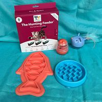 Group shot of all items including Hunting Feeder box, two slow feeder bowls, two treat dispensers