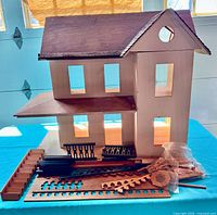 Front angle of dollhouse with loose wooden parts