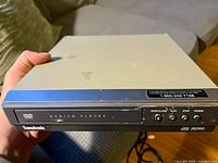 Front view showing brand, DVD/CD Player label and control buttons