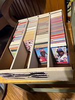 Top view of four-row long box filled with baseball cards of various back designs and colors