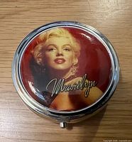 Lid showing Marilyn Monroe portrait and signature