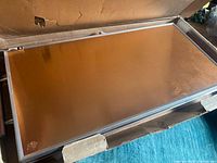 Warming tray inside original box showing copper-tone surface