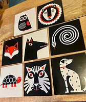 All eight square animal art cards laid out on a table